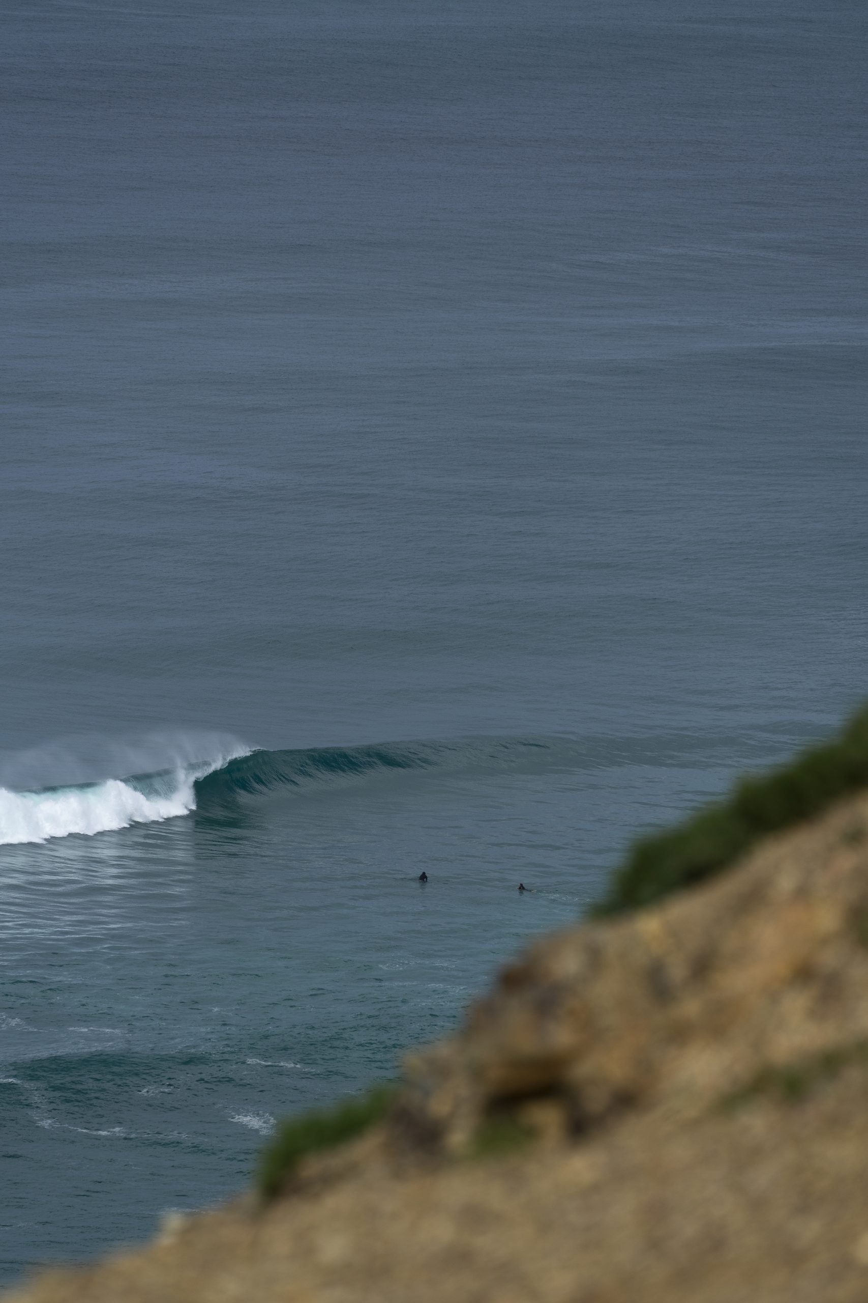Surfistas a remar em direção à onda
